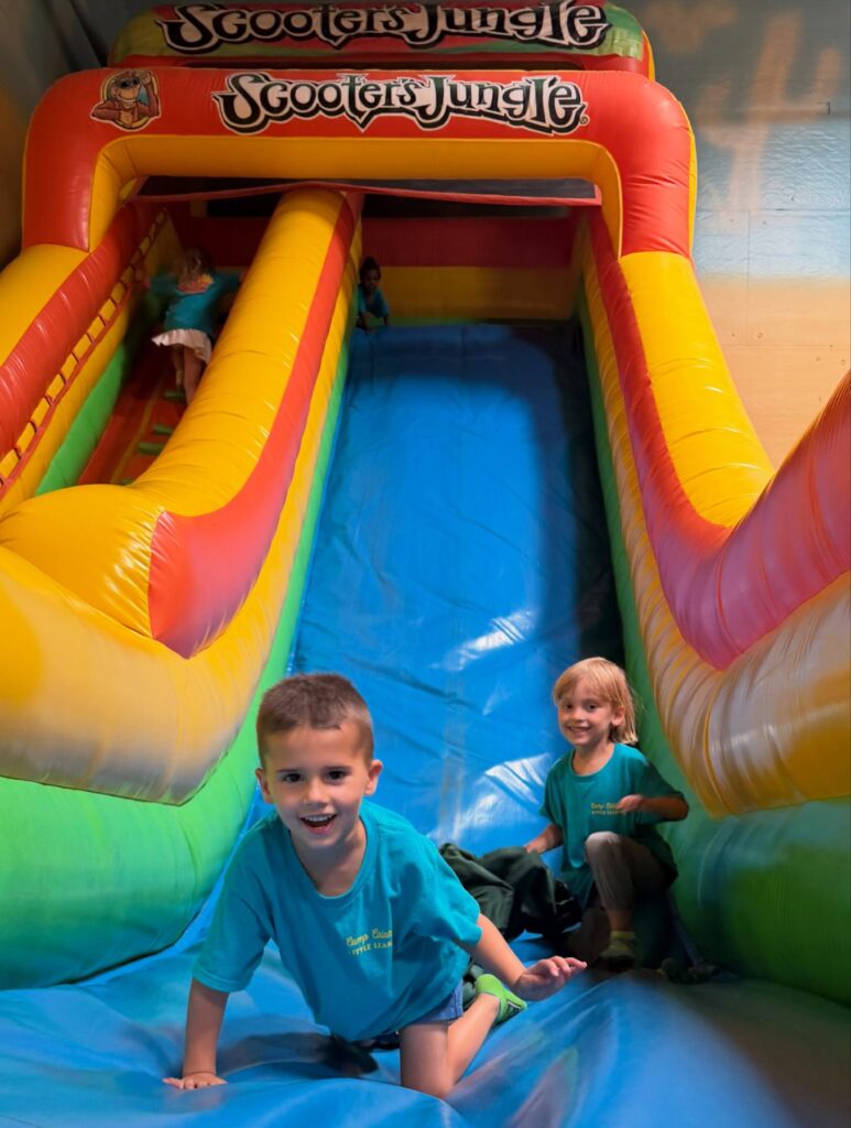 Campers sliding down an inflatable slide at Scooter's Jungle Valencia