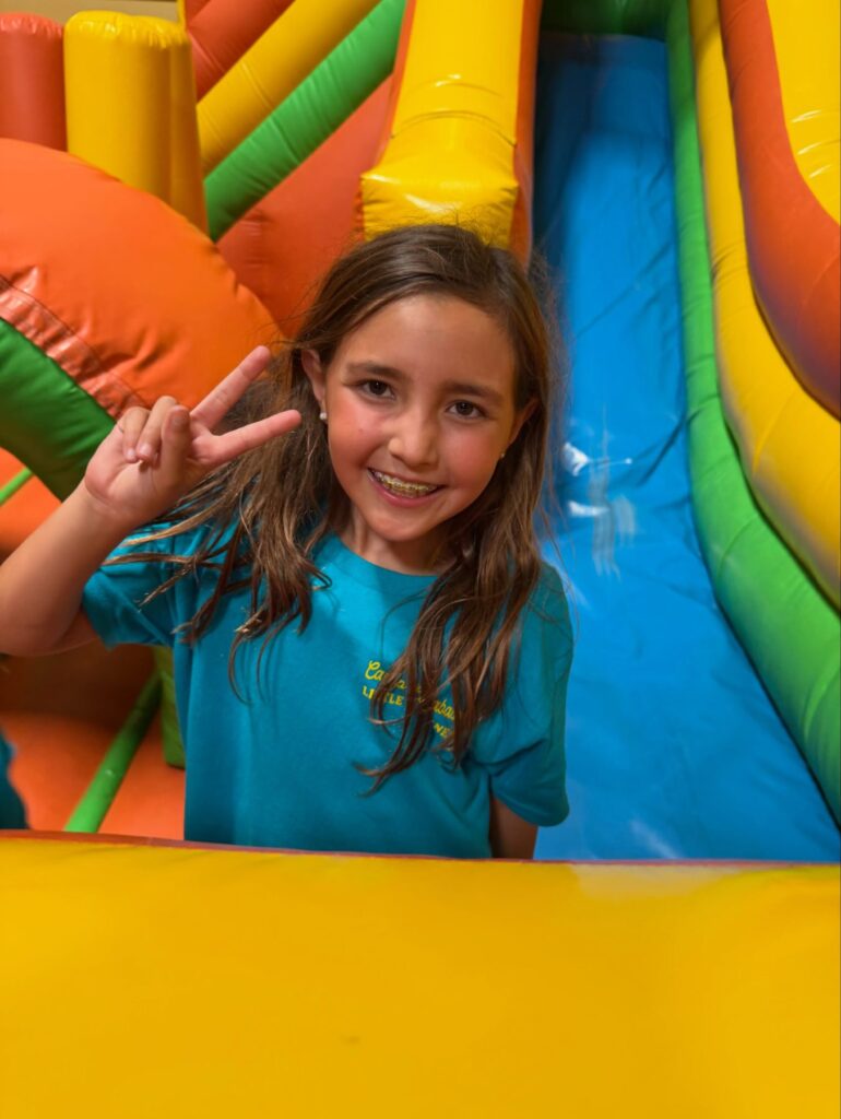Camper flashing a peace sign on an inflatable slide